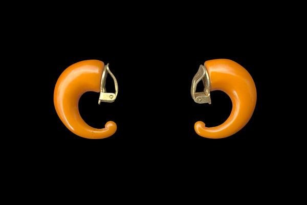 Horizontal side view of 1930s vintage butterscotch French Bakelite half hoop clip-on earrings.