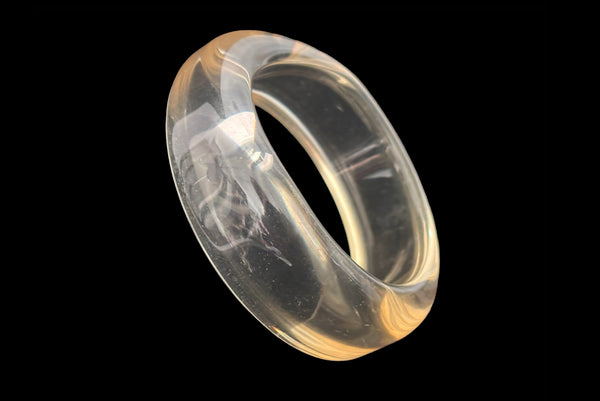 Horizontal perspective view of 1980s vintage clear Lucite asymmetrical bangle bracelet.