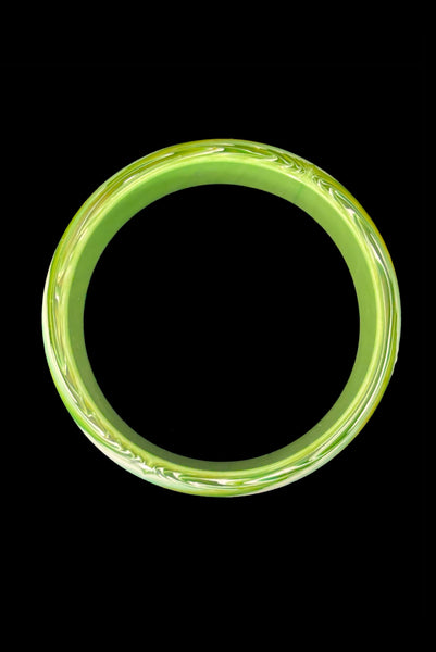 Vertical bottom view of 1960s vintage green, chartreuse, and white feathered Lucite plastic domed bangle bracelet.