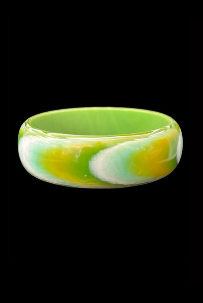 Vertical front view of 1960s vintage green, chartreuse, and white feathered Lucite plastic domed bangle bracelet.