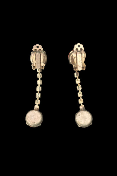 Vertical back view of 1950s vintage round pink glass cabochon top and drop iridescent pink rhinestone clip-on earrings.