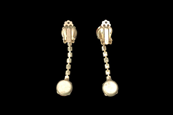 Horizontal back view of 1950s vintage round pink glass cabochon top and drop iridescent pink rhinestone clip-on earrings.