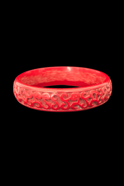 Vertical front view of 1950s vintage red cinnabar scroll carved lacquered Asian bangle bracelet.