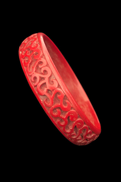 Vertical perspective view of 1950s vintage red cinnabar scroll carved lacquered Asian bangle bracelet.
