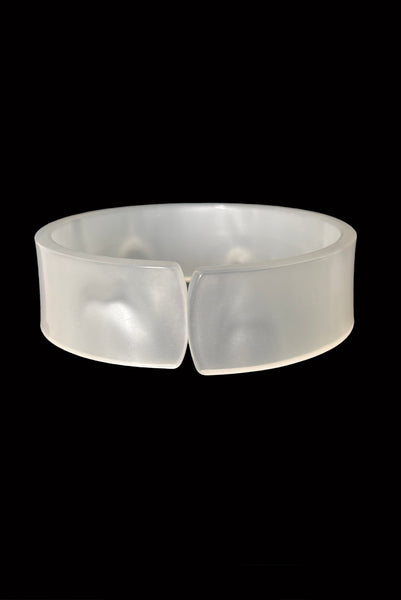 Vertical front view of 1950s vintage white moonglow Lucite plastic split sliced bangle bracelet.