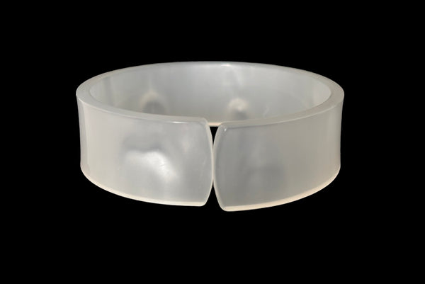 Horizontal front view of 1950s vintage white moonglow Lucite plastic split sliced bangle bracelet.