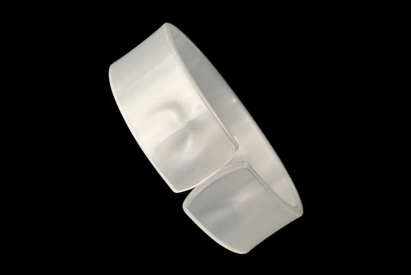 Horizontal perspective view of 1950s vintage white moonglow Lucite plastic split sliced bangle bracelet.