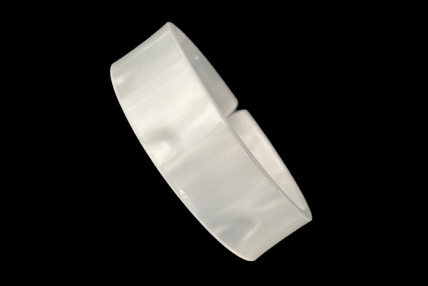 Horizontal perspective view of 1950s vintage white moonglow Lucite plastic split sliced bangle bracelet.