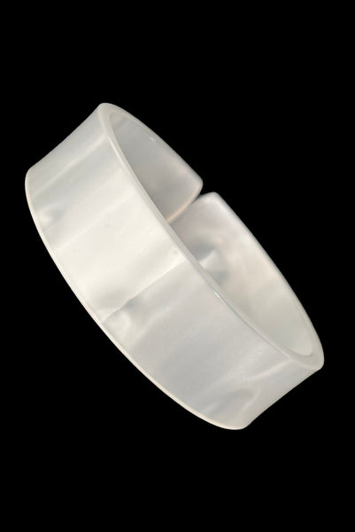 Vertical perspective view of 1950s vintage white moonglow Lucite plastic split sliced bangle bracelet.