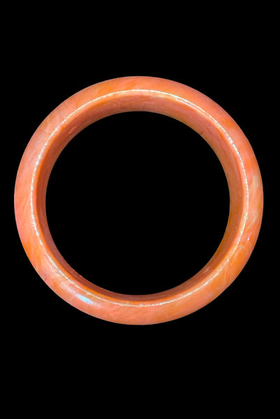 Vertical bottom view of 1980s iridescent orange and crackled orange and white plastic bangle bracelet set of two (2). Showing the iridescent domed bangle.