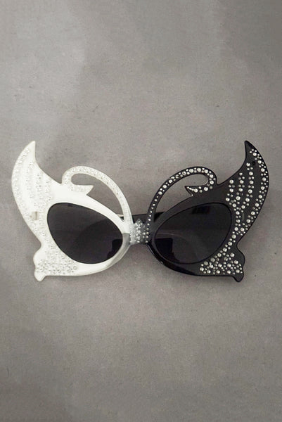 Vertical front view of early 2000s y2k vintage black and white plastic butterfly/insect rhinestone effect retro sunglasses.