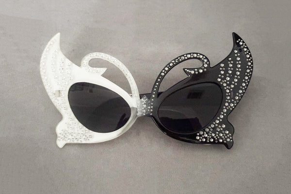 Horizontal front view of early 2000s y2k vintage black and white plastic butterfly/insect rhinestone effect retro sunglasses.