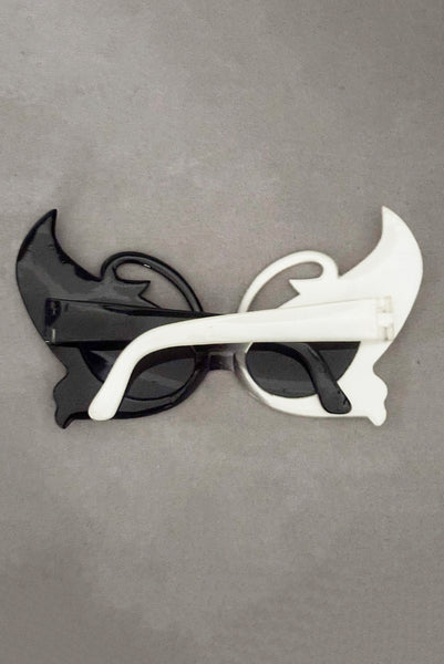 Vertical back view of early 2000s y2k vintage black and white plastic butterfly/insect rhinestone effect retro sunglasses.