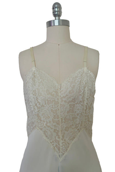 Bodice front view of 1950s vintage white sheer lace sweetheart neckline full slip by Vanity Fair, small to medium. Showing the floral patterned lace and adjustable straps.