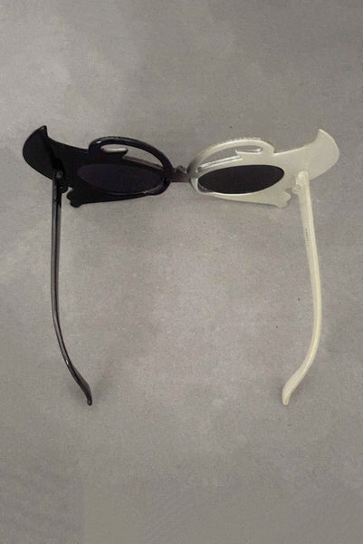 Vertical top view of early 2000s y2k vintage black and white plastic butterfly/insect rhinestone effect retro sunglasses.