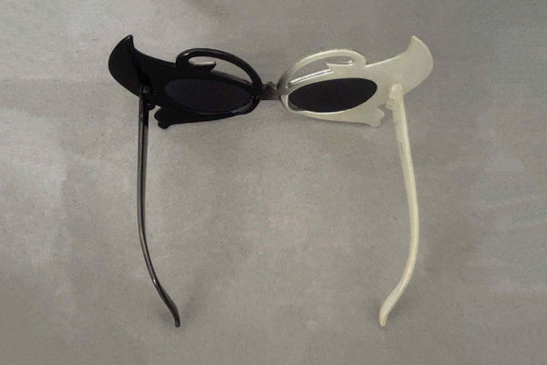 Horizontal top view of early 2000s y2k vintage black and white plastic butterfly/insect rhinestone effect retro sunglasses.