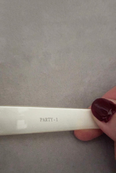 Detail view of early 2000s y2k vintage black and white plastic butterfly/insect rhinestone effect retro sunglasses. Showing "Party 1" stamped on the inside of the white arm.