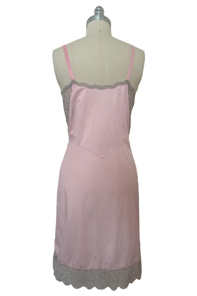 Back view of 1960s vintage pale pink nylon and gray lace full slip, extra small to small.