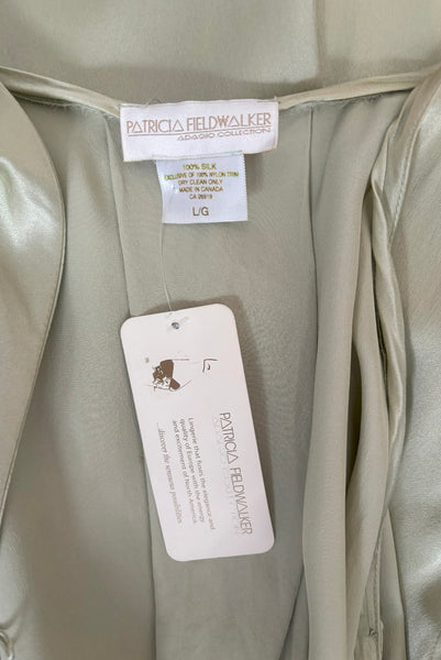 Interior detail view of 2000s y2k vintage new with tags sage green silk charmeuse robe by Patricia Fieldwalker, size medium to large. Showing the Patricia Fieldwalker label, size and paper store tags.