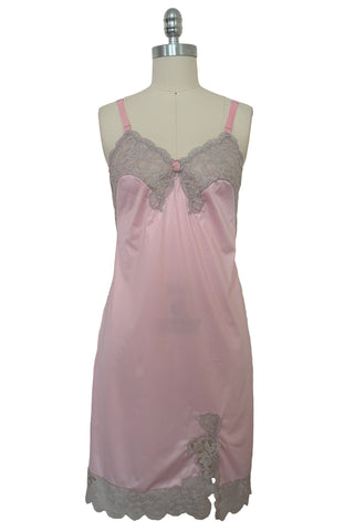 Front view of 1960s vintage pale pink nylon and gray lace full slip, extra small to small.