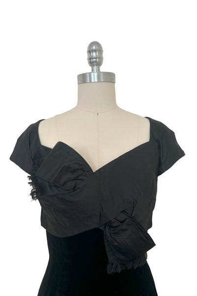 Bodice front view of 1950s vintage black silk satin and velvet wiggle cocktail dress, by Nathan Strong, extra small to small. Showing the cap sleeves, sweetheart neckline, and bust bow detail.