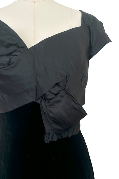 Detail view of 1950s vintage black silk satin and velvet wiggle cocktail dress, by Nathan Strong, extra small to small. Showing the cap sleeves, sweetheart neckline, and bust bow detail.