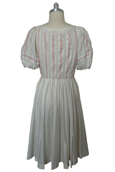 Back view of 1950s vintage white cotton scoop neck, button front, gathered half sleeve, pleated skirt peasant dress with red embroidery, size small to medium.