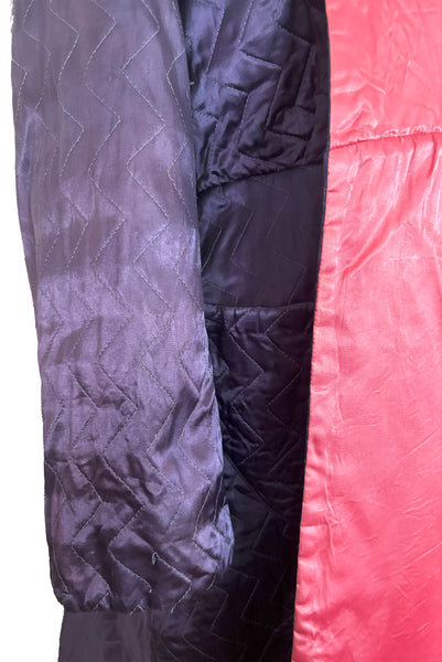 Detail view of 1940s purple satin quilted robe with pink satin lining by Sandora, medium to large. Showing some of the breaks in the quilting.