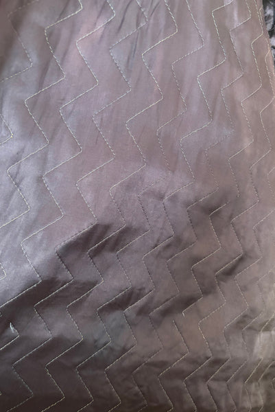 Detail view of 1940s purple satin quilted robe with pink satin lining by Sandora, medium to large. Showing the zig-zag quilting pattern.