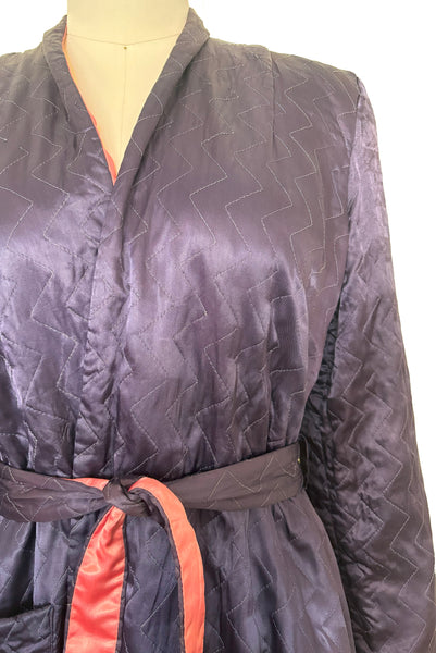 Detail view of 1940s purple satin quilted robe with pink satin lining by Sandora, medium to large.
