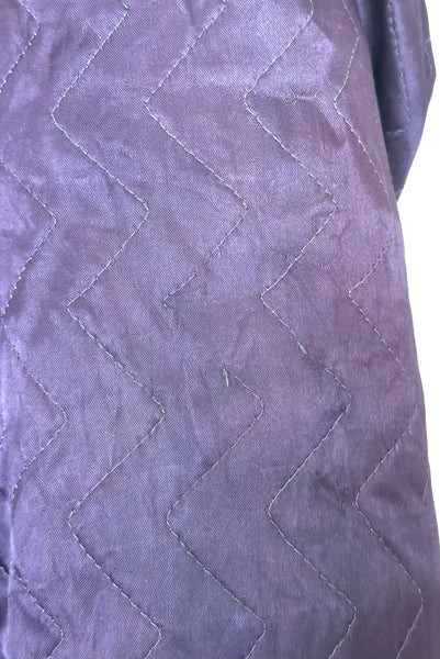 Detail view of 1940s purple satin quilted robe with pink satin lining by Sandora, medium to large. Showing some of the breaks in the quilting.