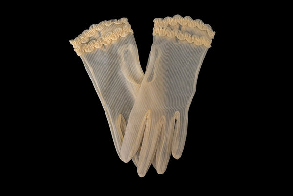 Horizontal pair view of 1950s vintage wrist length sheer yellow striped nylon ruffled cuff gloves. On a black background.