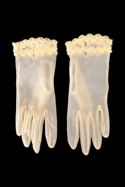 Vertical front view of 1950s vintage wrist length sheer yellow striped nylon ruffled cuff gloves. On a black background.