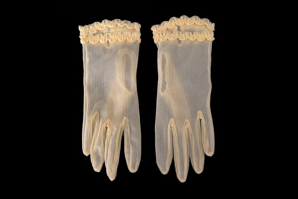 Horizontal front view of 1950s vintage wrist length sheer yellow striped nylon ruffled cuff gloves. On a black background.