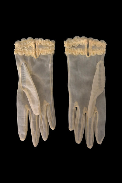 Vertical back view of 1950s vintage wrist length sheer yellow striped nylon ruffled cuff gloves. On a black background.