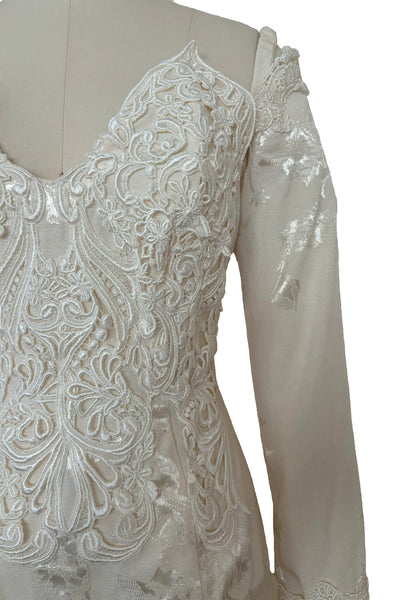 Bodice detail view of 1990s vintage cream jacquard & lace pointed sweetheart neckline, long sleeve, bustle back wedding dress by Jessica McClintock, extra small to small. Showing the elastic shoulder straps and cream Venice lace embellished neckline.