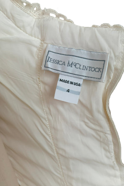 Interior detail view of 1990s vintage cream jacquard & lace pointed sweetheart neckline, long sleeve, bustle back wedding dress by Jessica McClintock, extra small to small. Showing the Jessica McClintock label, and size 4 tag.