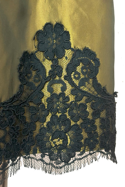 Detail view of 1990s vintage black velvet and olive green taffeta cocktail dress by Rimini, size medium to large. Showing the corded lace trim at the hem.