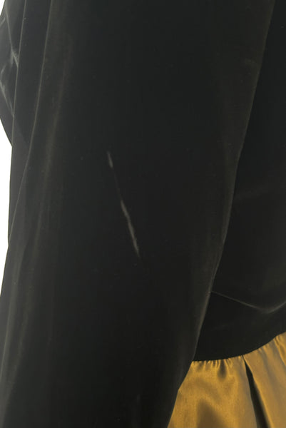Detail view of 1990s vintage black velvet and olive green taffeta cocktail dress by Rimini, size medium to large. Showing a line of  pressed nap on the sleeve.