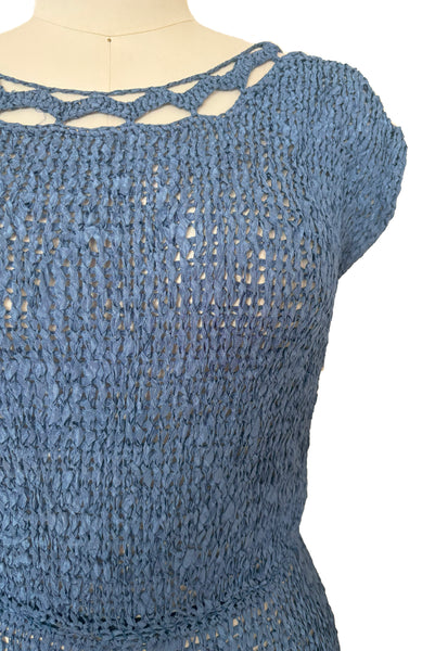 Detail view of 1950s vintage periwinkle rayon ribbon crochet dress, medium to extra large. Showing the cut out, scalloped, scoop neckline, cap sleeves, and elastic waist. 