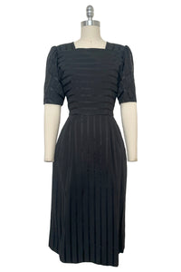 Front view of vintage 1970s black satin and matte striped square neck puff sleeve dress by Lanz, extra small to small.