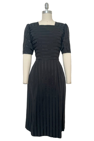 Front view of vintage 1970s black satin and matte striped square neck puff sleeve dress by Lanz, extra small to small.