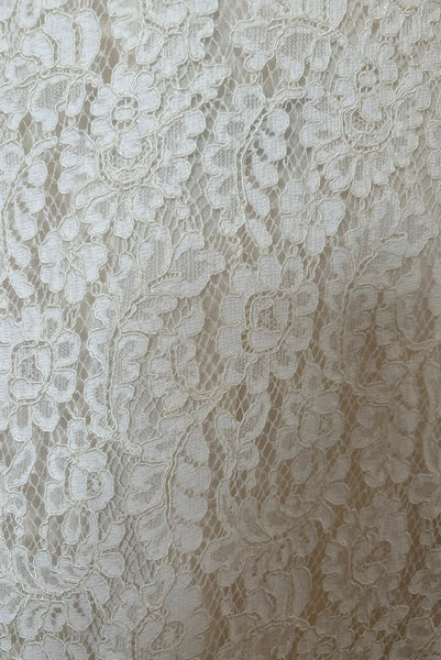 Detail view of 1960s vintage white corded lace sleeveless sheath dress by Jonathan Logan, size small to medium. Showing a close-up of the white floral corded lace.