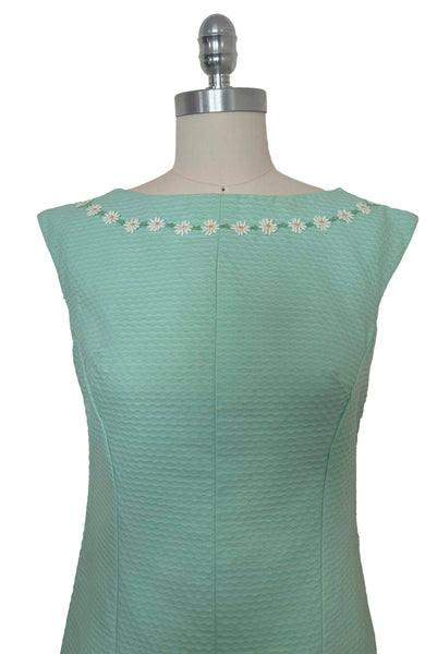 Bodice front view of 1960s vintage mint green cotton pique daisy trimmed sheath dress, size extra small to small.