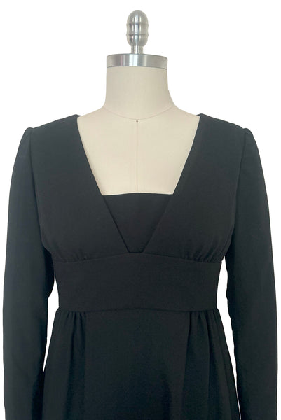 Bodice front view of 1960s vintage Mod crepe empire waist little black dress, by Teal Traina, size small to medium. The modesty panel at the center can be folded down to show more cleavage.