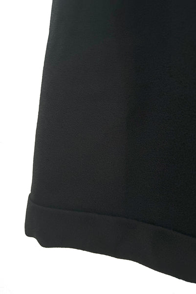 Detail view of 1960s vintage Mod crepe empire waist little black dress, by Teal Traina, size small to medium. Showing the banded hem.