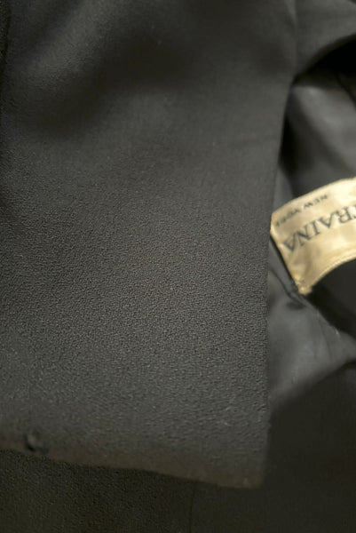 Detail view of 1960s vintage Mod crepe empire waist little black dress, by Teal Traina, size small to medium. Showing a small hole at the shoulder.