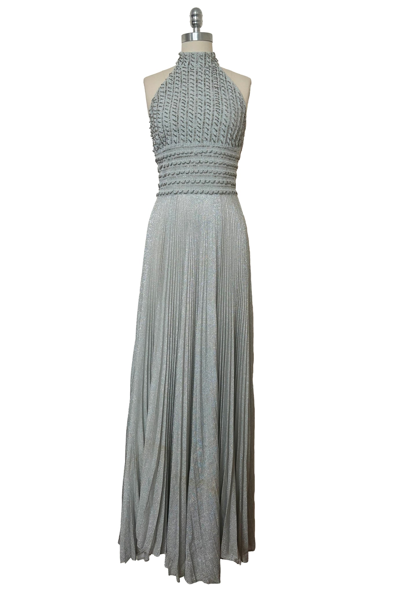 Front view of 1960s silver Lurex and white beaded evening gown by Mignon, medium to large. Showing the halter neckline and pleated maxi skirt.
