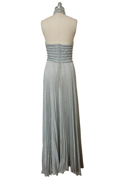 Back view of 1960s silver Lurex and white beaded evening gown by Mignon, medium to large. Showing the halter neckline and pleated maxi skirt.