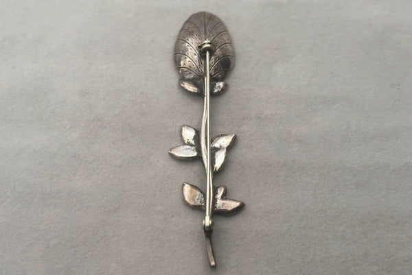 Horizontal back view of 1950s vintage silver floral spoon shaped botanical brooch.